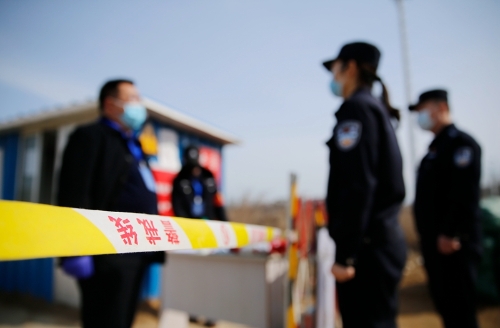 路静在警戒线外与社区的志愿者交谈防疫工作