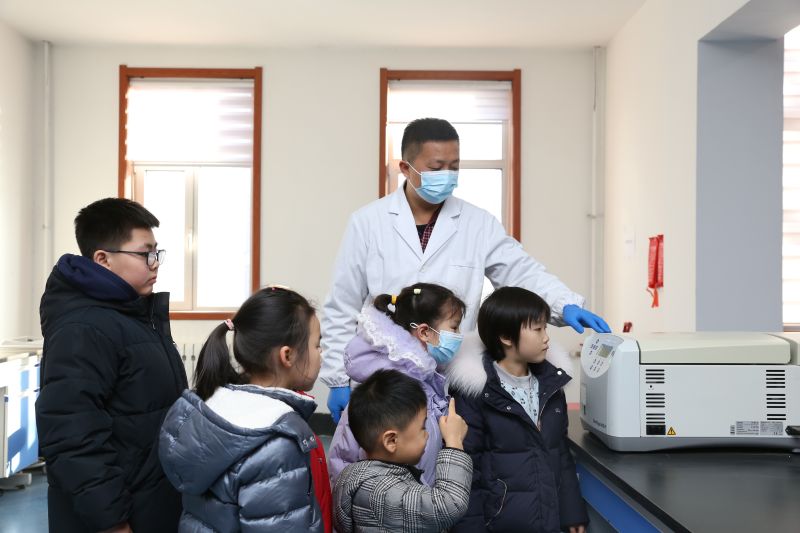 图为：工程师向小朋友们介绍实验室设备 尹日顺摄